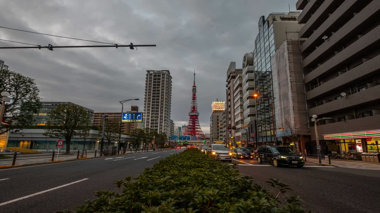 4K Time Lapse - Zoom out Tokyo Tower iconic landmark of Tokyo Japan with car and transportation light in the evening with grass on foreground - Tokyo Japan
