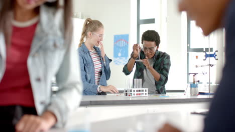 in high school, teenagers conducting science experiment with test tubes in classroom