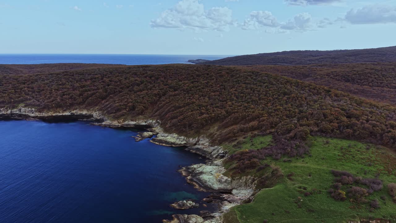 Scenic aerial view of a coastal landscape with hills and clear sea