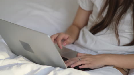 woman working on laptop in bed