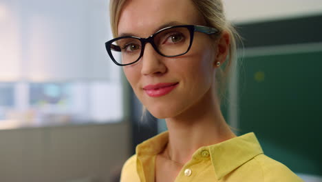 teacher posing at camera in classroom. woman with positive face expression