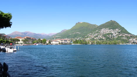 panning shot of the beautiful coastline in lugano, switzerland during a sunny day