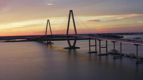 drone orbits left showing cars driving across cooper river bridge in charleston south carolina