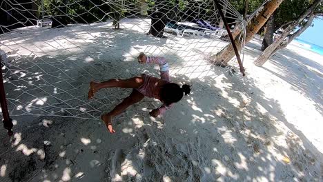 down syndrome child playing in a hammock on the beach