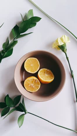 lemons in a bowl with flowers and plants