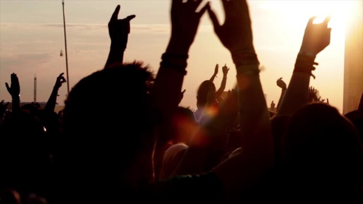 Unrecognizable people holding hands up during concert