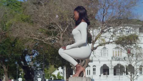 Enjoying-a-day-in-the-city,-a-young-girl-in-a-white-bodysuit-has-whitehall-castle-in-the-background