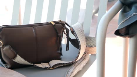 brown leather shoulder bag on a chair