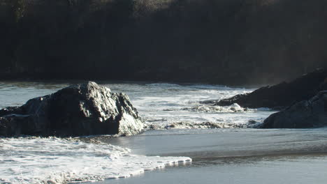 breathtaking beach in kinsale, ireland, sunny day, waves splash rock