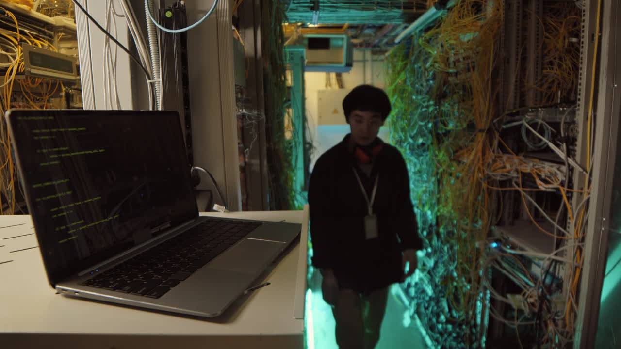 System Administrator Coding on Laptop in Data Center