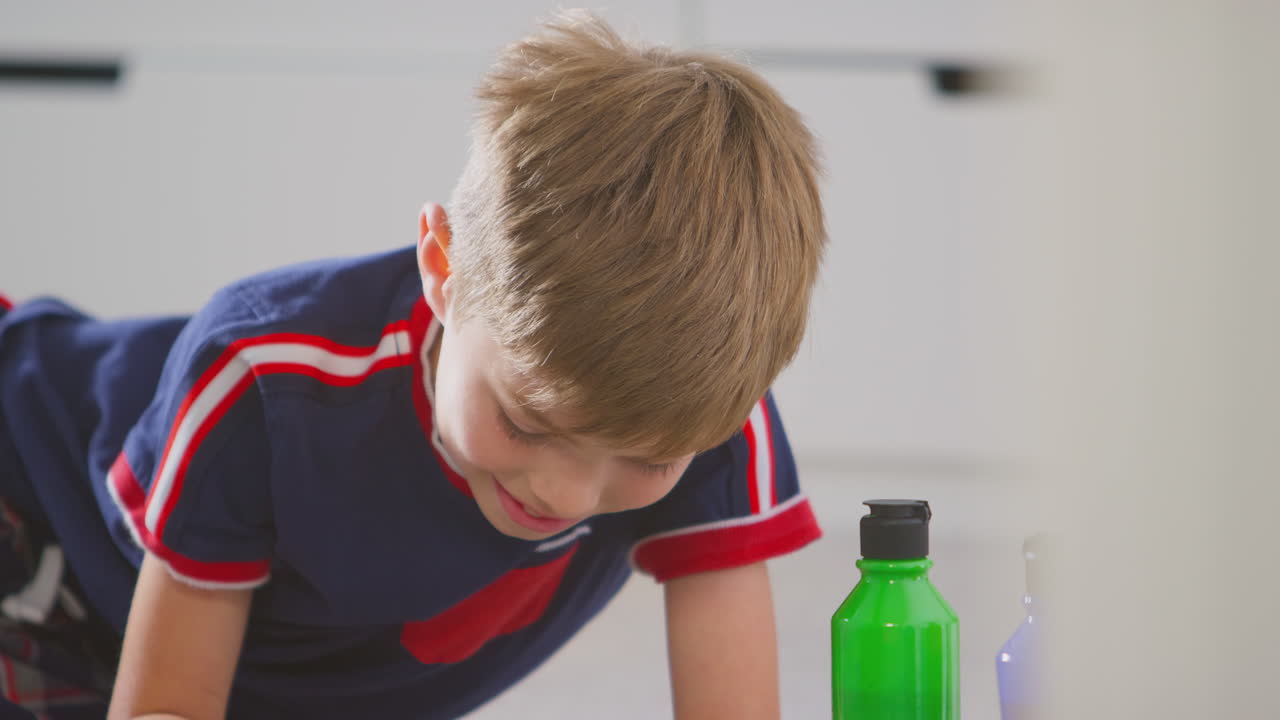 침실 에 있는 소년 이 생일 이나 어머니 의 날 을 축하 하기 위해 카드 를 만드는 것