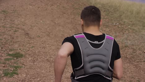 man running on a trail with weight vest