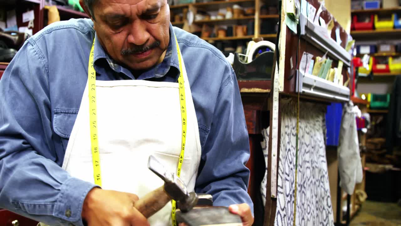 zapatero haciendo zapatos con un martillo