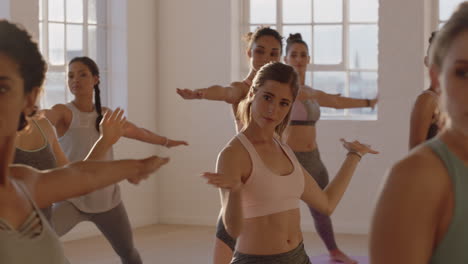 Clase-De-Yoga-De-Hermosas-Mujeres-Practican-Pose-Guerrera-Disfrutando-De-Un-Estilo-De-Vida-Saludable-Haciendo-Ejercicio-En-El-Gimnasio-Meditación-Grupal-Al-Amanecer