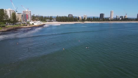 澳洲昆士蘭州東南部黃金海岸市的burleigh heads平靜海灘上漂浮的遊客衝浪者