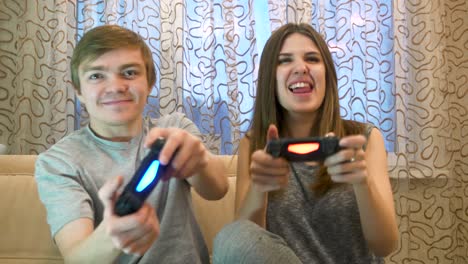una pareja joven jugando videojuegos.