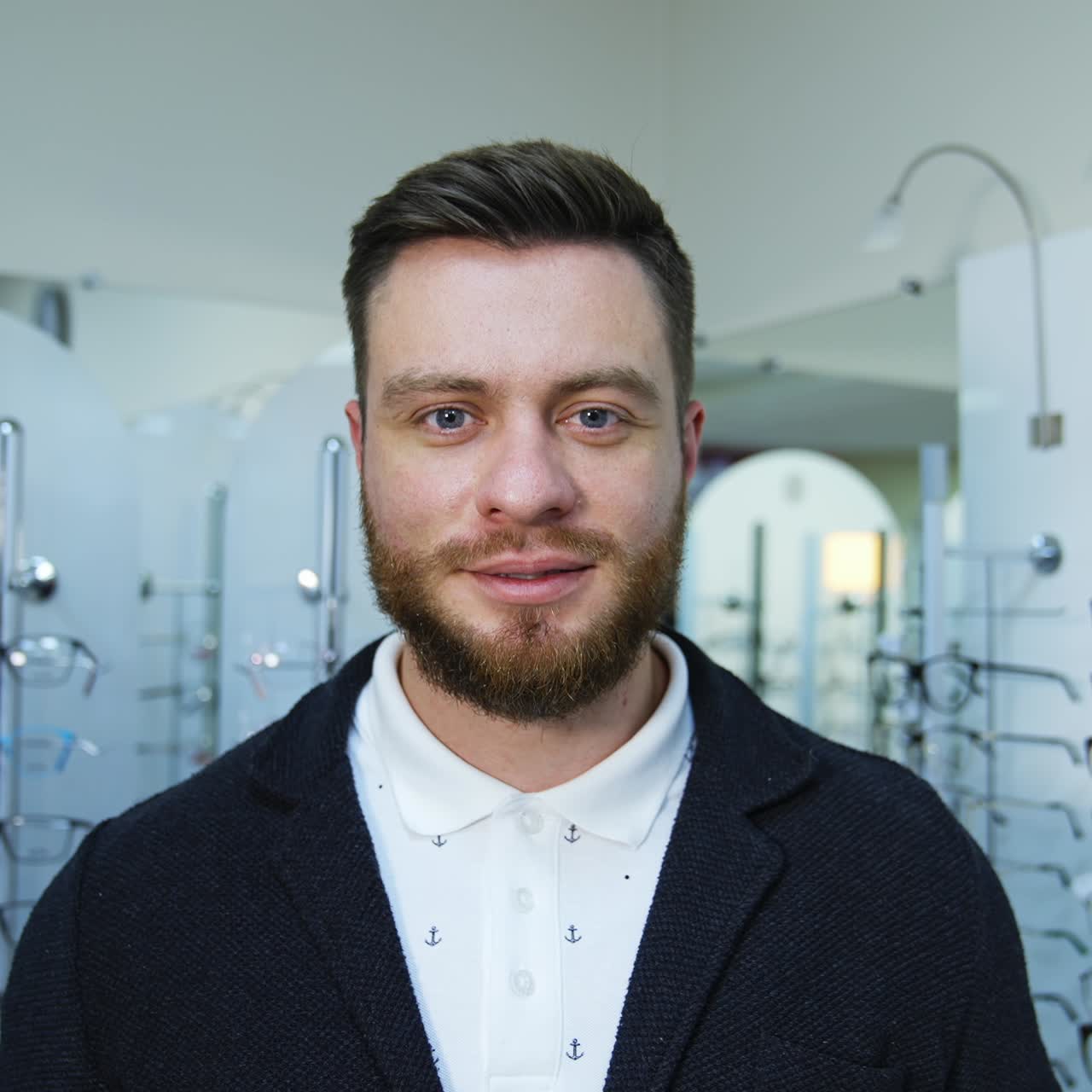 Man in optical shop choosing eyeglasses