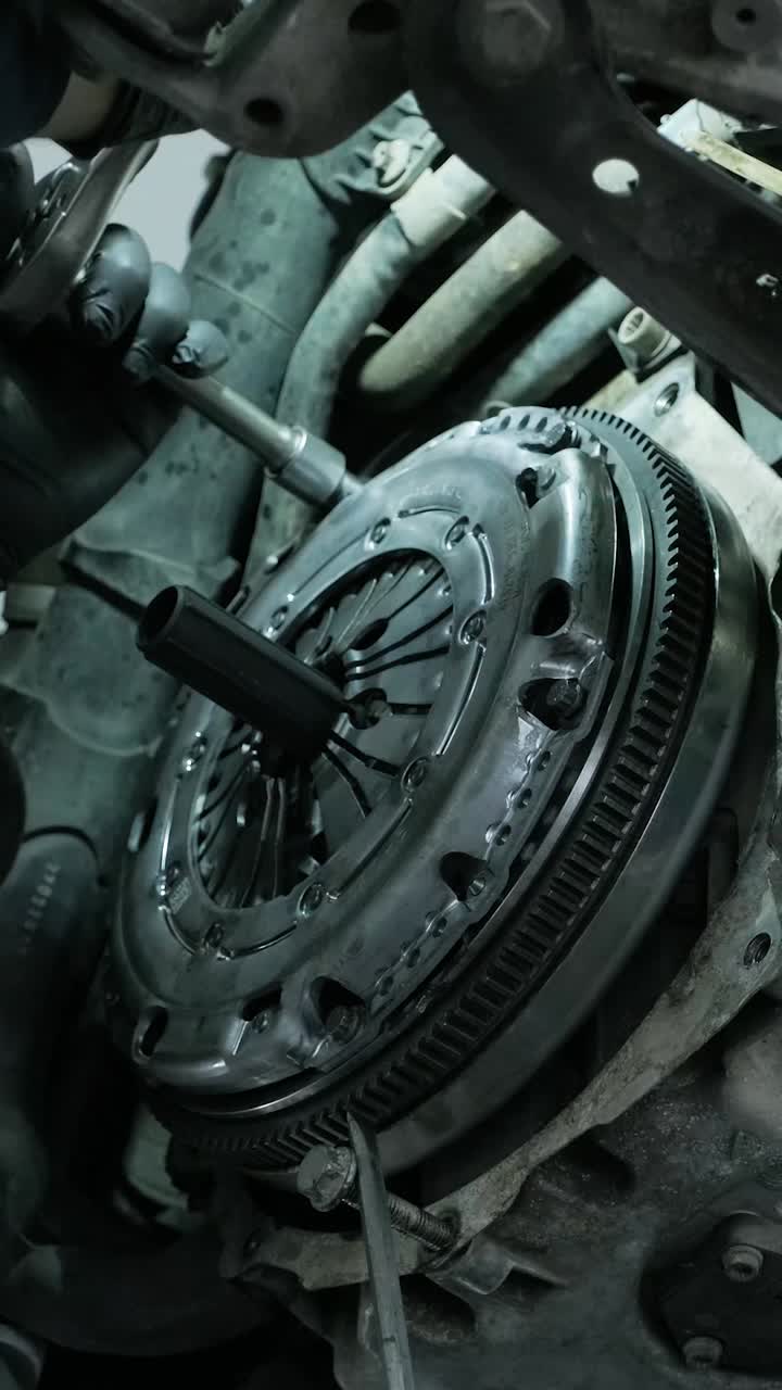 Mechanic Tightening Bolts on a Car Clutch Assembly in a Workshop
