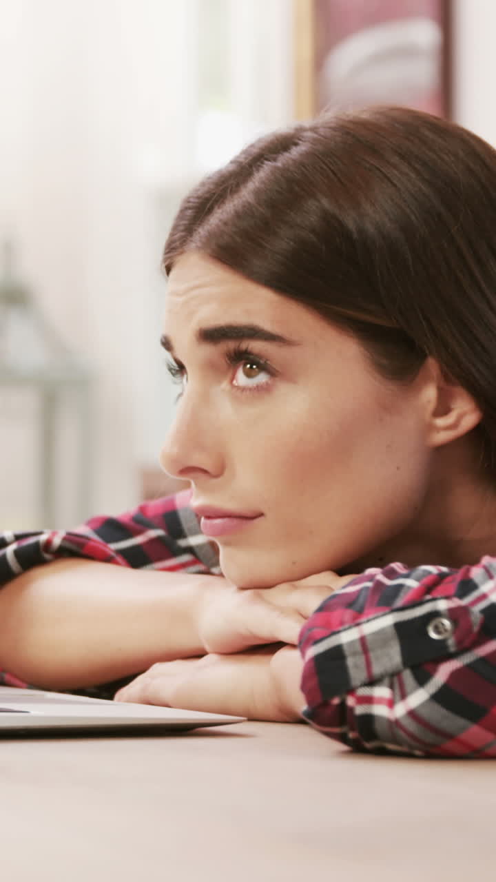 mujer agotada usando una computadora portátil mientras bebe café