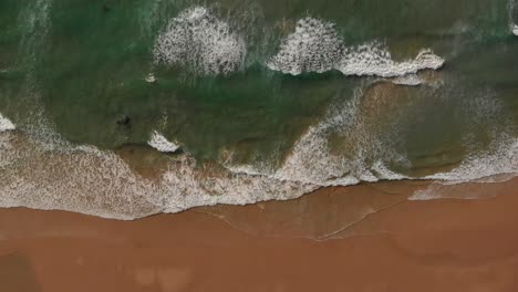 Antena-Relajante-Sobre-La-Playa-De-Malhão,-Olas-Suaves-Rompen-En-La-Arena-Dorada