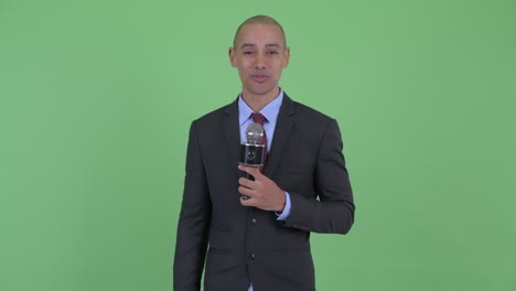 happy handsome bald multi ethnic businessman with microphone