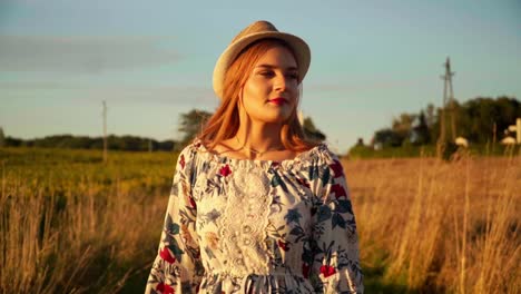 stunning hd footage of a beautiful young woman in a dress, wearing a knitted hat and red lipstick, joyfully walking through a wheat field