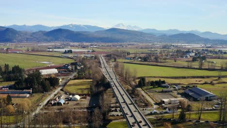 Cars-Moving-On-Highway-Bridge-In-Nature-Landscape---aerial-drone-shot