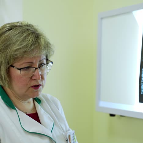 patient at medical consultation. female nurse talking with elderly woman patient