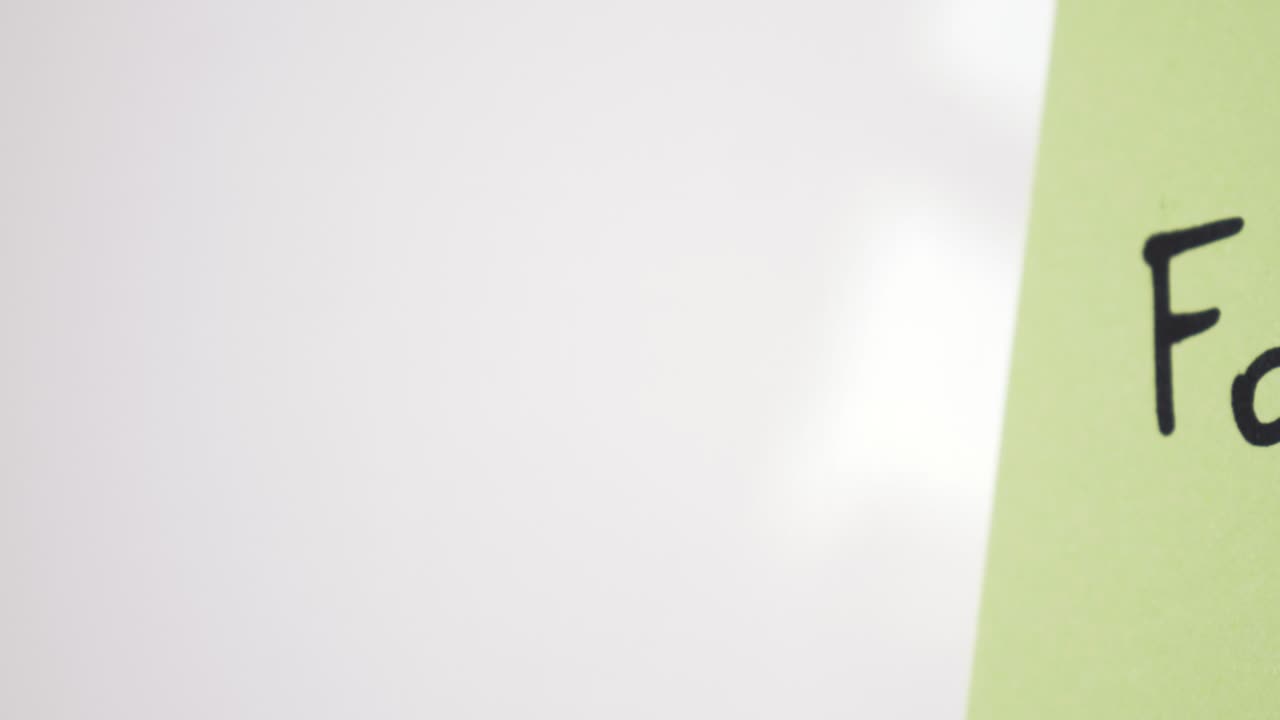 Pan reveal of Forex text on green note held by magnet on whiteboard with selective focus