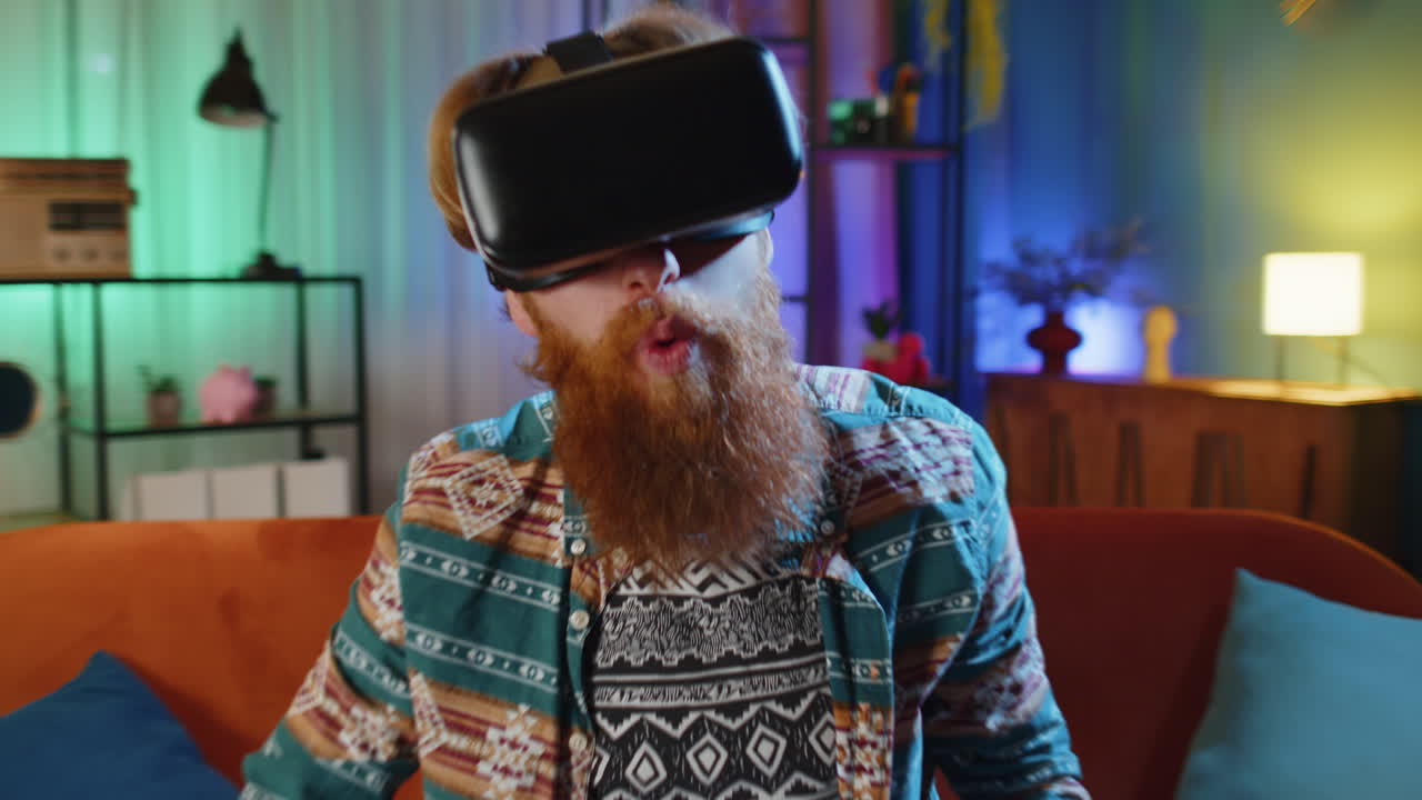 Uomo che usa cuffie di tecnologia futuristica di realtà virtuale per giocare a videogiochi 3D di simulazione a casa