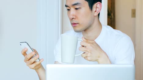 man using mobile phone while having coffee 4k