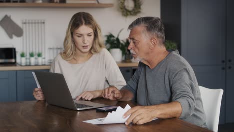 caucasian senior man and adult daughter counting home finance.