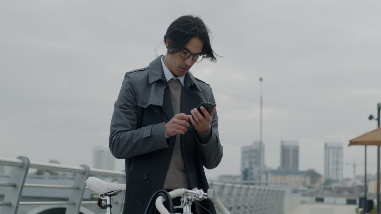 도시 다리에서 스마트폰을 사용하는 사업가