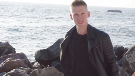 un joven lleva su tabla larga y sonríe