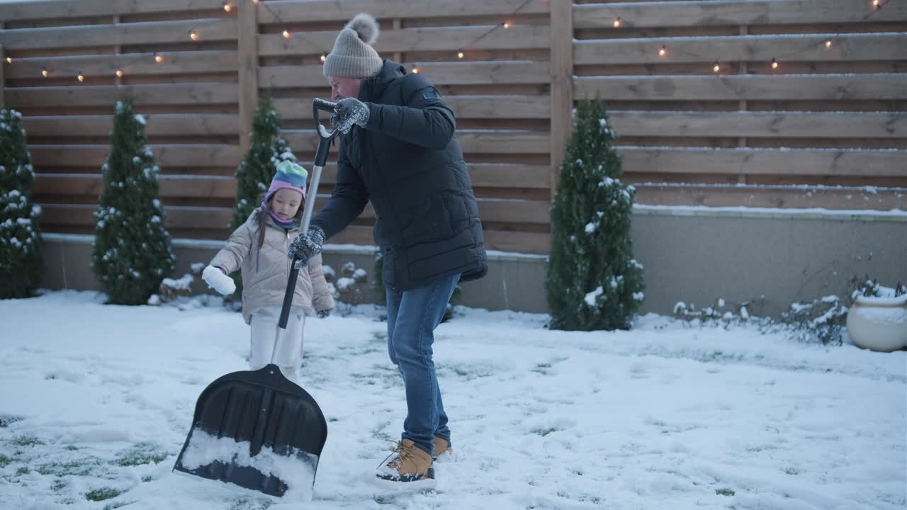 할아버지와 손녀가 눈 속에서 재미를 느끼고 있습니다.