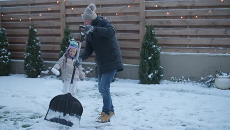 grandfather and granddaughter having fun in the snow