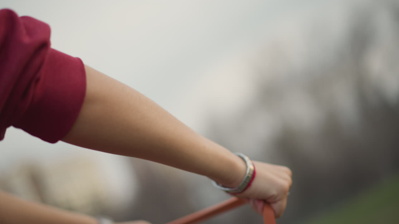 Calm Woman Elongates Rubber Band, Peaceful Woman Pulls Stretchy Band Skyward In Calm Environment, Tranquil Woman Extends Elastic Band Towards Sky Surrounded By Peaceful Natural Atmosphere