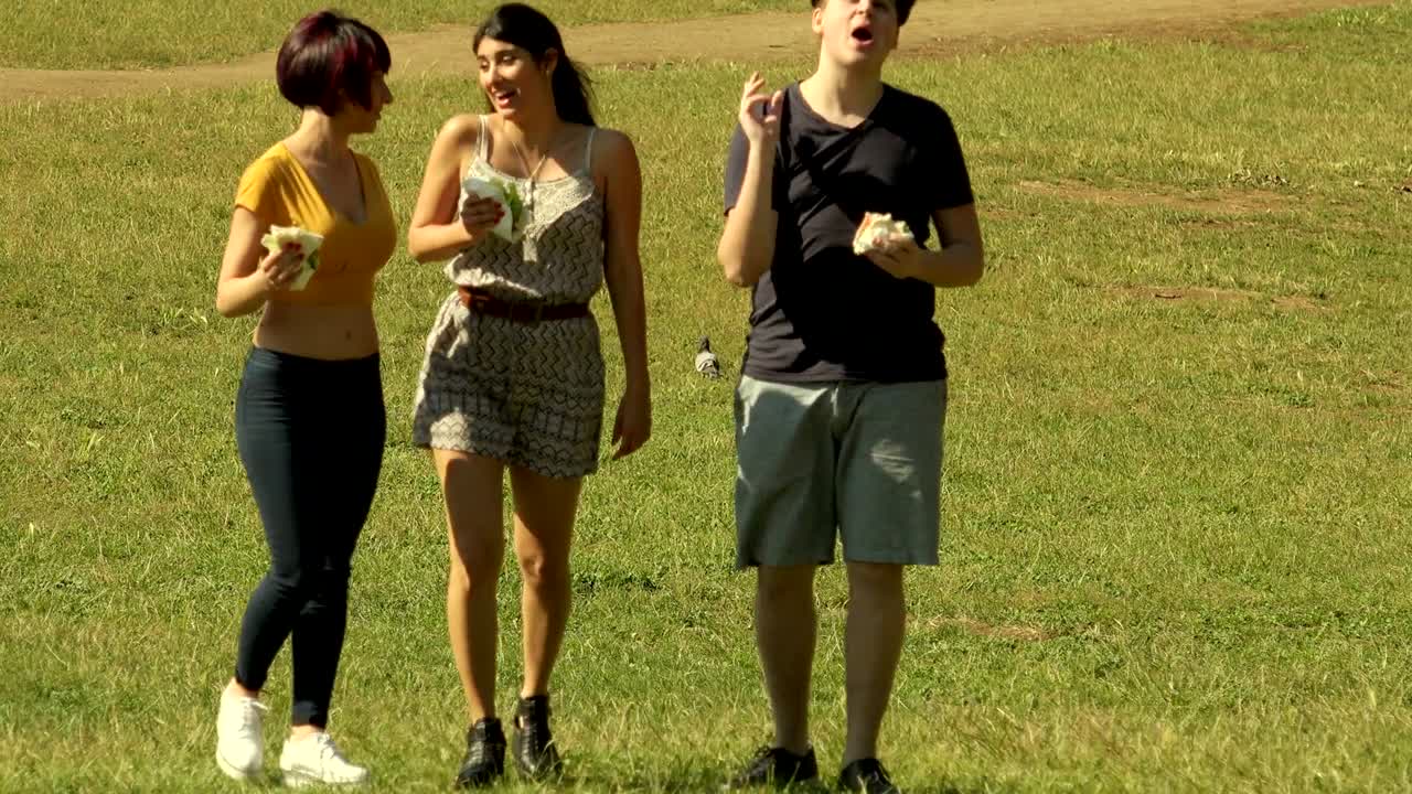 공원에서 산책하는 학생들이 샌드위치를 즐기고 있습니다.