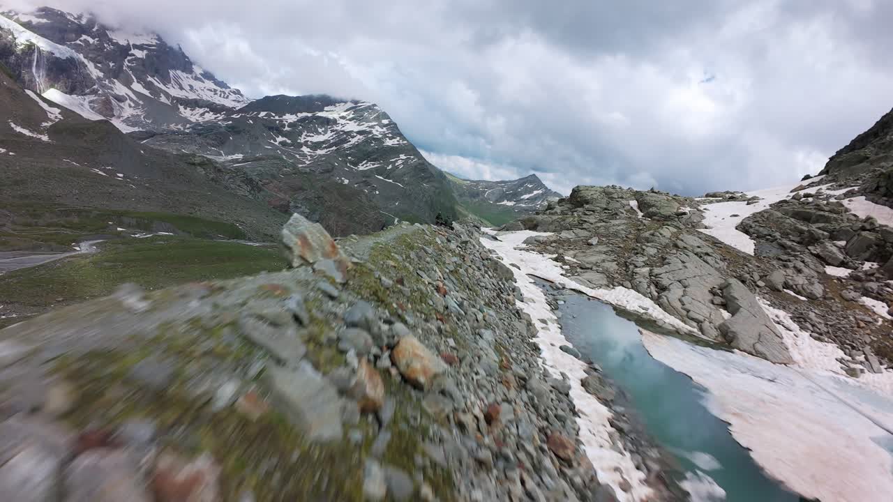 valmalenco, italia - una pintoresca vista de terreno escarpado, parcialmente cubierto por manchas de nieve dentro del glaciar fellaria - toma en fpv