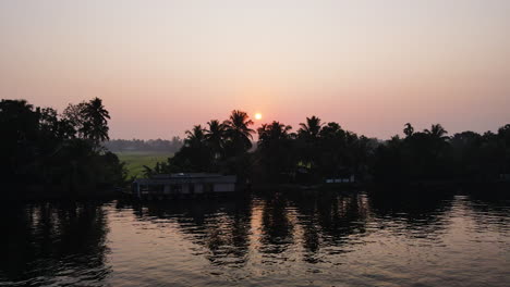 Vista-Panorámica-De-La-Naturaleza-Con-Casa-Flotante-En-Alappuzha,-Kerala-India-Durante-La-Puesta-De-Sol