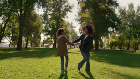 happy mom playing daughter on sunny day in park. joyful motherhood concept.