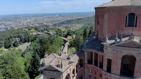 Aerial-shot-of-Santuario-di-San-Luca,-revealing-the-city-and-the-arcade-in-the-backgraound,-Bologna,-Italy