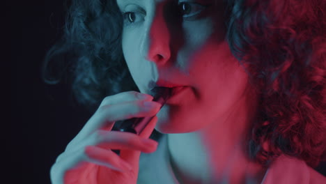 woman vaping in colorful light
