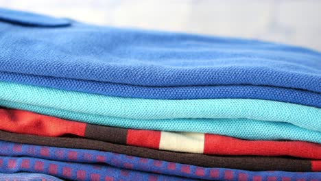 a stack of folded shirts in various colors