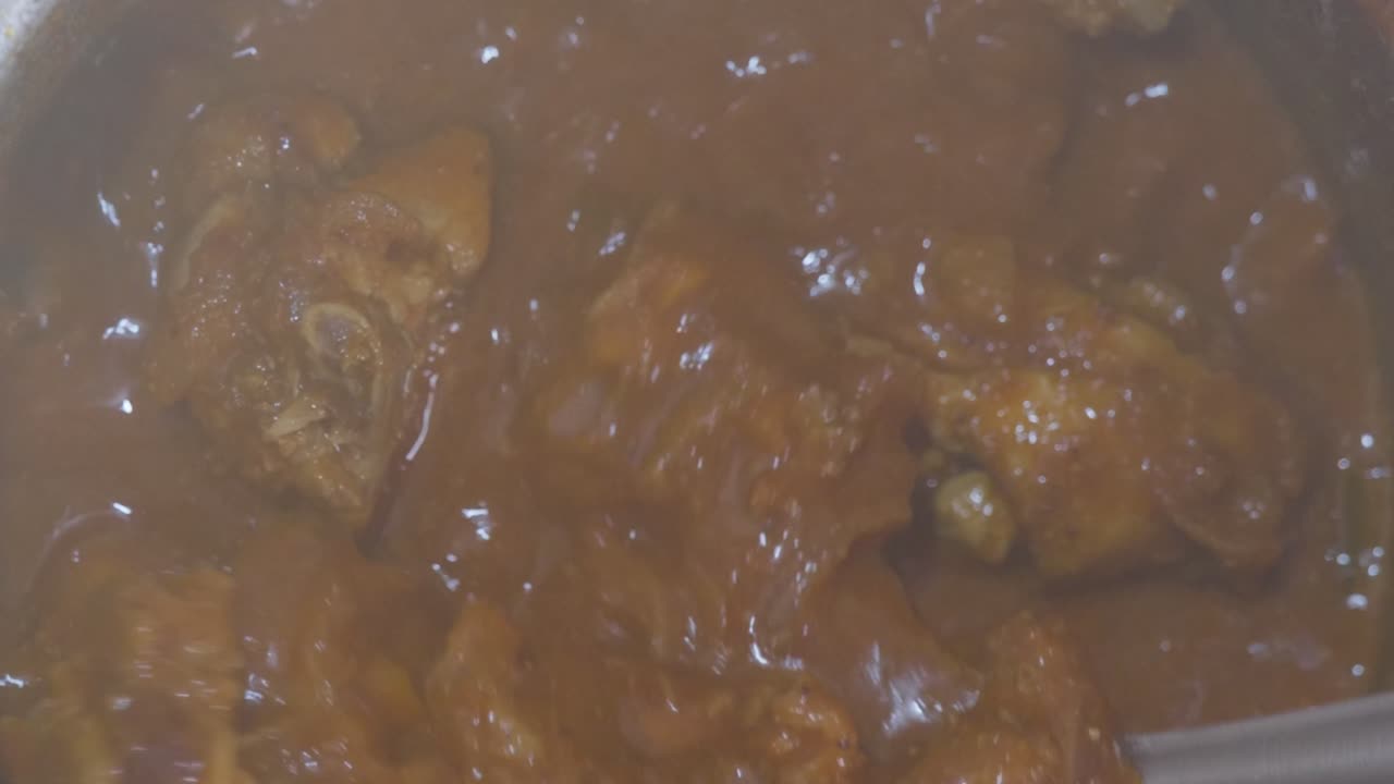 Cucina tradizionale di curry di pollo con spezie e fumo indiani. Primo piano, scatto interno, 4K