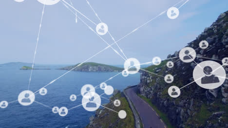 animation of network of profile icons against aerial view of a road and sea