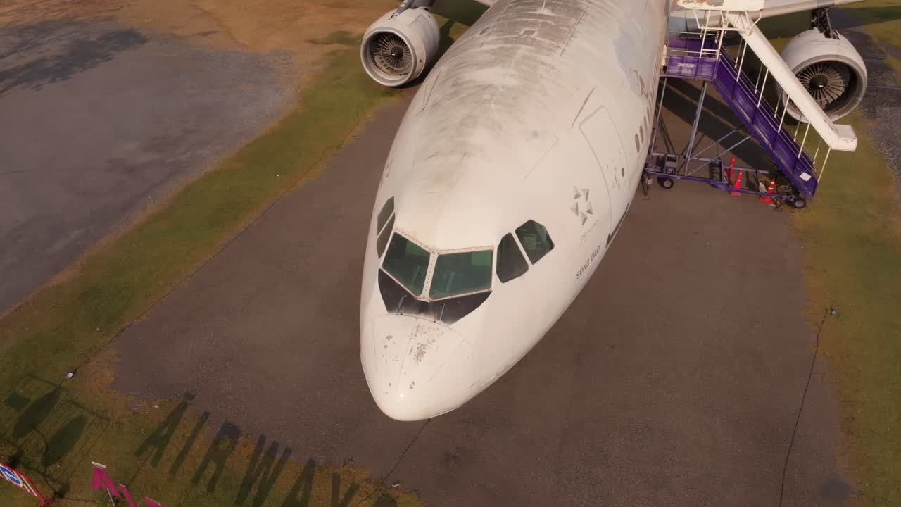 Il traffico scorre accanto a un aeroplano a terra nella campagna thailandese.