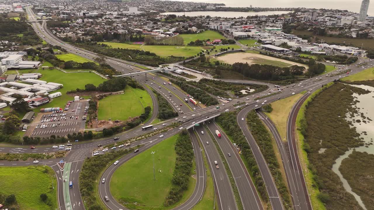 Busy traffic scene on multi lane highway and bridges of Auckland, New Zealand. Aerial top down shot