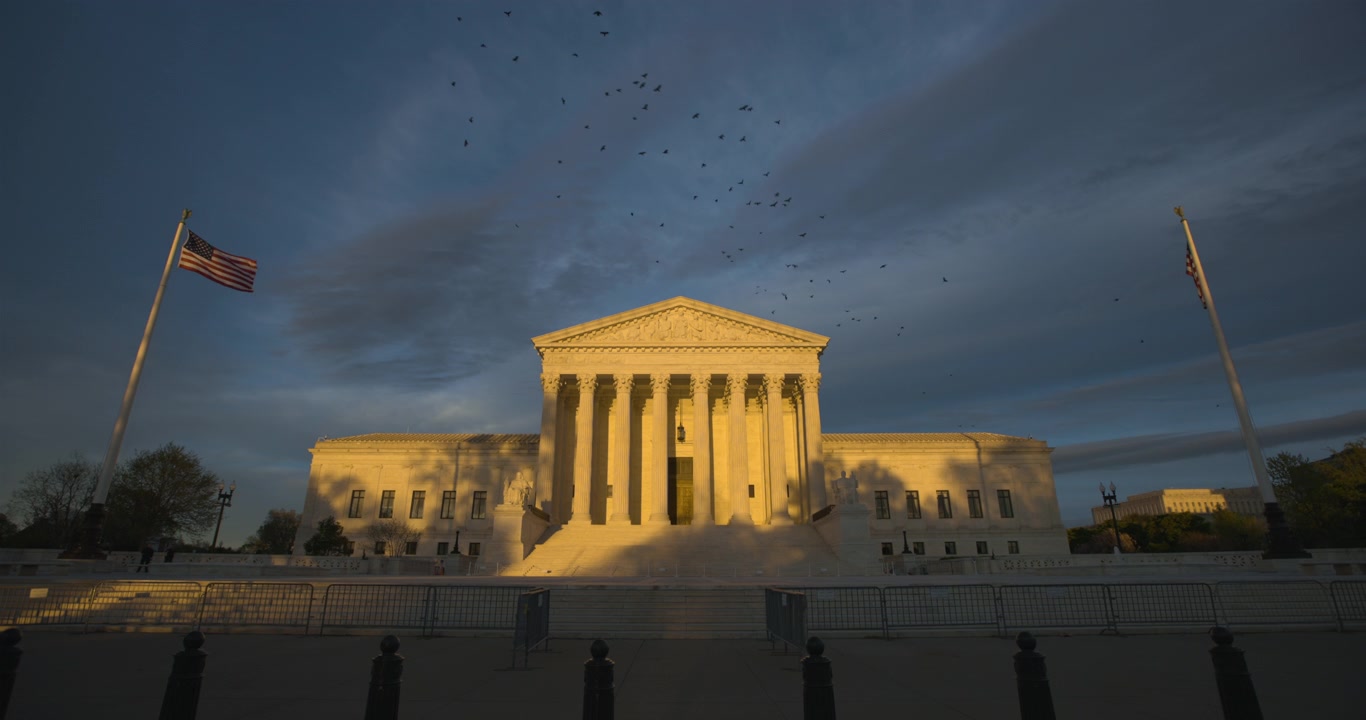 Corte Suprema degli Stati Uniti con un cielo drammatico nel tardo pomeriggio e uno stormo di uccelli che volteggia in alto