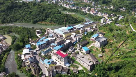 hills with vegetation and a river with buildings in hefeng county hubei province china